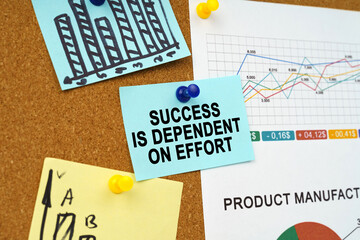 Business charts and stickers with the inscription hang on the board - SUCCESS IS DEPENDENT ON EFFORT