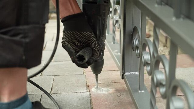 Builder Drills a hole in the wall with a Hammer Drill. Close-up of hammer drill perforator making hole