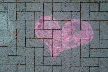 Straßenpflaster auf Gehweg mit pink Herz, von Kindern gemalt