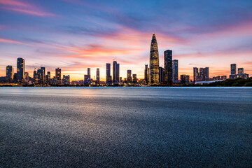 Asphalt road and urban skyline with modern buildings at sunset in Shenzhen, Guangdong Province, China.