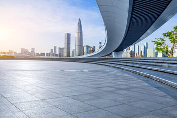 Empty square floor and pedestrian bridge with city skyline in Shenzhen, Guangdong Province, China.