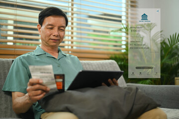 Happy senior man using online payment methods, banking on digital tablet.