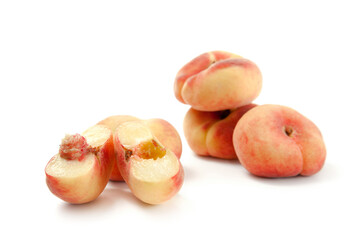 Half and several whole saturn peaches or flat peaches isolated on white background with clipping...