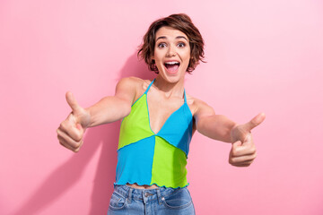 Photo of impressed funky lady wear green blue tank top showing two thumbs up isolated pink color...