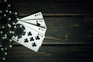 Gambling game of poker with a combination of two pairs. Chips and cards on a dark vintage table in...