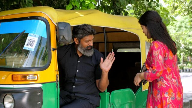 Beautiful Indian woman taking auto rikshaw - transportation services  Delhi auto rickshaw. A woman commuting via local transportation service to travel in the city - office girl  morning  daily com...