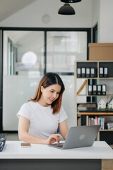 Asian businesswoman working with working notepad, tablet and laptop documents .