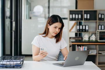 Asian businesswoman working with working notepad, tablet and laptop documents .