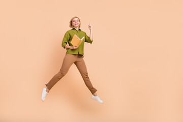 Fototapeta na wymiar Full size photo of smart nice girl wear khaki shirt with book in hand raising finger up have idea isolated on pastel color background