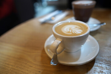 Flower latte art on latte coffee in the white cup