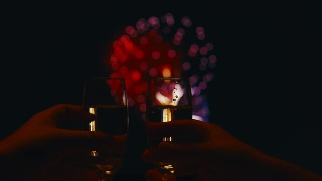 Celebratory toast with champagne and fireworks in the background. Shot with RED helium camera in 8K.  