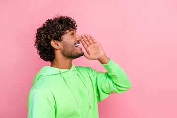 Side photo of funny young guy brown curly hair wearing green hoodie touch cheek announce his...
