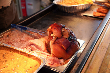 roast pork with crispy skin for sale at street vendor. Hog roast food stall at Christmas market in the UK