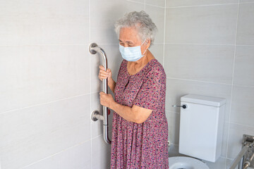 Asian senior woman patient use toilet bathroom handle security in nursing hospital, healthy strong...