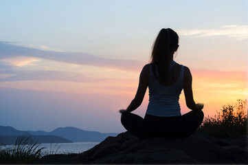 Silhouette of woman practicing yoga outdoors