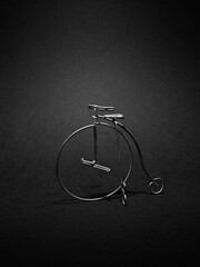 Old fashioned bicycle on black background. Minimalistic still life.