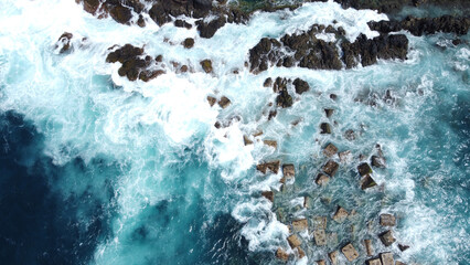 Aerial photo of strong and powerful ocean with huge waves. Rocks.