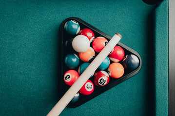 Sports game of billiards on a green cloth.Multi colored billiard balls in the form of a triangle...