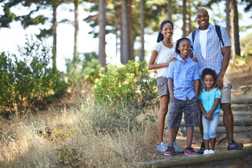 Portrait, smile and hiking with a black family in nature together for travel, freedom or adventure. Mother, father and children outdoor in the forest, environment of woods for summer bonding