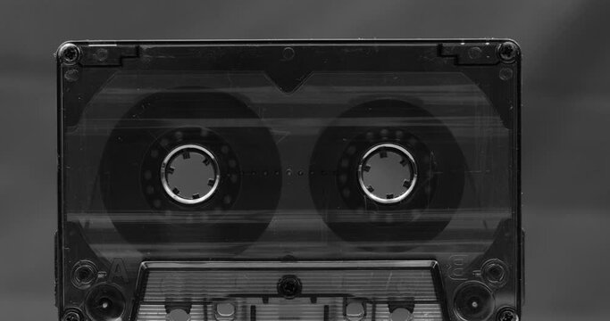 Audio cassette tape in use, rotation of rolls of film, white background