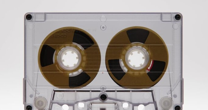 Audio cassette tape in use, rotation of rolls of film, white background