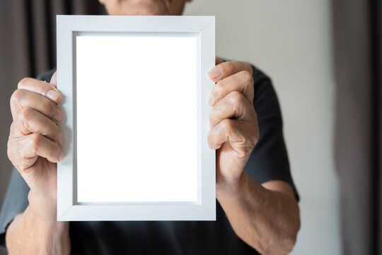 Asian older man showing blank empty white picture frame for your advertising text message