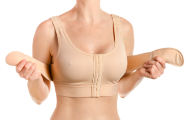 Woman wearing compressing bra with a stipe after breast augmentation