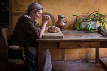 Woman in prayer for bread - obrazy, fototapety, plakaty
