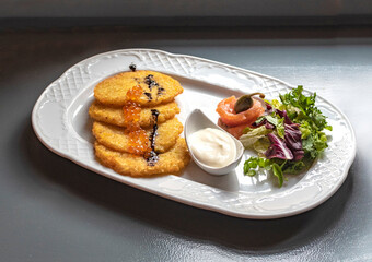 Potato pancakes with red caviar and vegetables
