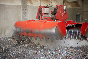 A red bridge crane grab during Waste derived fuel handling. Processing of municipal solid waste...