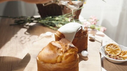 A Woman Glazing a Traditional Easter Cake . Sunlight Streaming in Through the Window onto the Table.