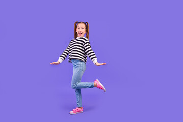 Fototapeta na wymiar Full length photo of carefree excited little child dressed striped pullover having fun empty space isolated purple color background