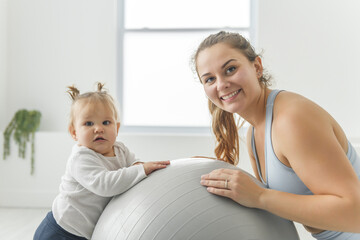 Fototapeta premium Sport Activities With Baby. Young Mom Exercising With Her Infant Son At Home