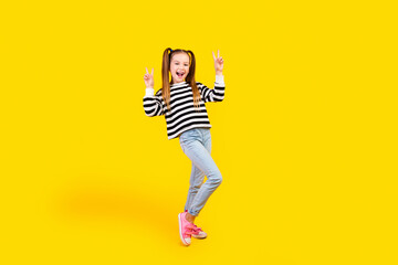 Fototapeta na wymiar Full length photo of cheerful positive little child dressed striped pullover showing two v-signs isolated yellow color background