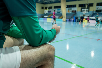 player watching an futsal game from the bench