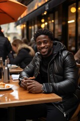 Happy Young Adult Sitting at a Cafe Table, Smiling and Relaxing