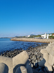 Fototapeta premium Jeju Island beach with breakwater and basalt rocks.