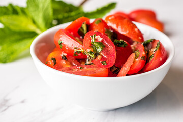 Marinated cherry tomatoes in a white bowl