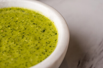 Green sauce in a white bowl