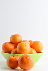 Close up, tangerines on white background and green porcelain plate.