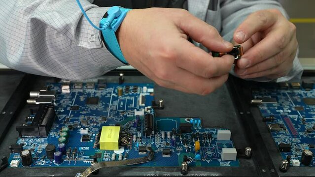 Modern High-Tech Electronics Factory Moving Manufacturing Conveyor: Professionals Doing Precision Work Assemble Circuit Boards, Processors, Microchips, Semiconductors.