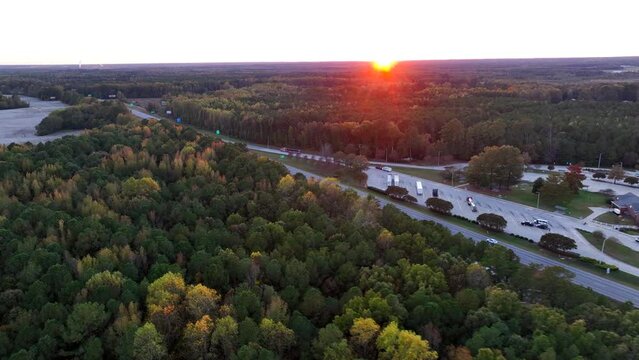Rest stop along an interstate highway in Appalachia, USA during autumn sunset. Aerial view of the state line and cotton field surrounded by woodlands.