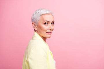 Close up portrait of beautiful businesswoman in yellow jacket posing when someone calls her in office isolated on pink color background