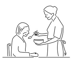 シニア女性の食事を介助する女性介護士