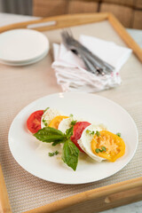 Tomato, basil, mozzarella salad on a white plate