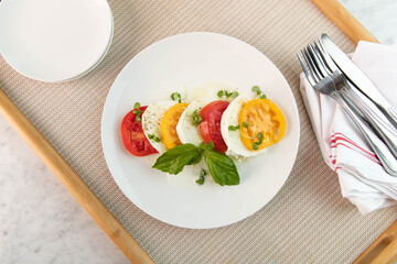 Tomato, basil, mozzarella salad on white plate