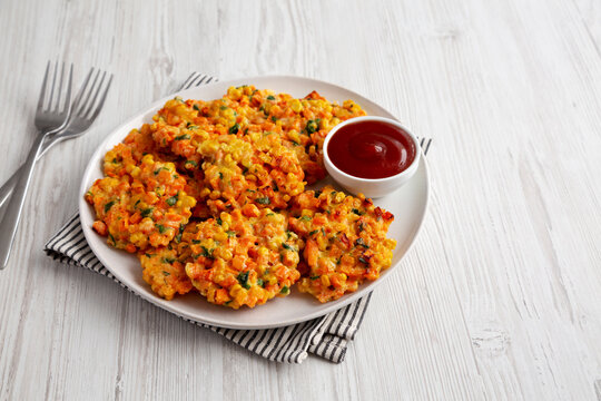 Homemade Carrot Corn Fritters with Ketchup on a Plate, side view.