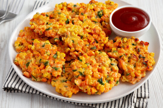 Homemade Carrot Corn Fritters with Ketchup on a Plate, side view. Close-up.