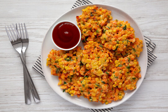 Homemade Carrot Corn Fritters with Ketchup on a Plate, top view. Flat lay, overhead, from above.