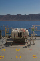 Muster station onboard a merchant ship at sea on the boat deck near liferaft